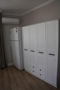 安塔利亚Royal Homes 503的厨房配有白色橱柜和冰箱。
