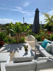 卡武埃鲁A Beira Do Vale, Carvoeiro的一个带沙发和遮阳伞的庭院