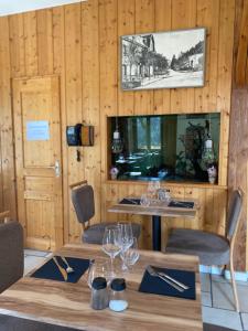 Chaux-des-CrotenayHôtel Restaurant des Lacs的用餐室配有带酒杯的桌子