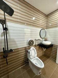 Bạc LiêuKhách sạn Anh Tuấn的一间带卫生间、水槽和镜子的浴室