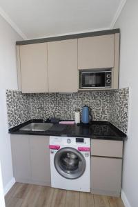 安塔利亚Royal Homes 505的厨房配有洗衣机和微波炉。