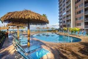 卡哈纳Deluxe Oceanview Maui Studio..New & Updated的一个带椅子和草伞的游泳池