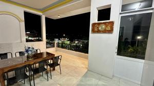 Bạc LiêuKhách sạn Anh Tuấn的一间带桌子的用餐室和一个阳台
