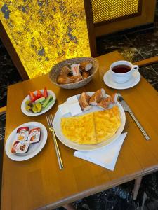 伊斯坦布尔Gold Corner Hotel的餐桌,早餐盘和咖啡盘