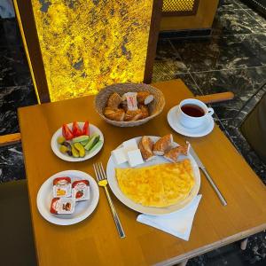 伊斯坦布尔Gold Corner Hotel的餐桌,早餐盘和咖啡盘