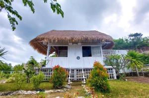 珀尼达岛Ocean Glamping Penida的茅草屋顶的白色小房子
