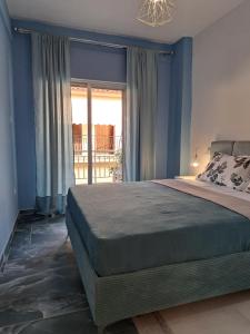 尼坡帝Gala Premium的一间卧室配有一张蓝色墙壁的床和一扇窗户
