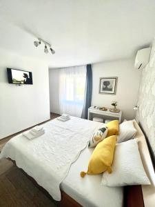 赫瓦尔Sun&Fun Studio Apartment的卧室配有一张带黄色枕头的大型白色床。