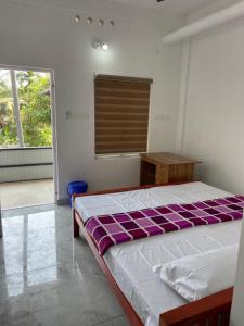 KotamangalamNew star homes的一间卧室配有一张床、一张桌子和一个窗户。