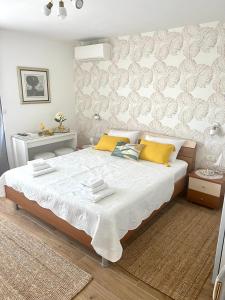 赫瓦尔Sun&Fun Studio Apartment的卧室配有一张带黄色枕头的大型白色床。