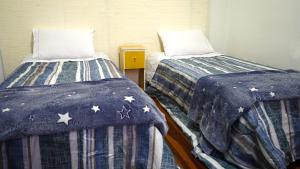 阿雷格里港Casinha的两张睡床彼此相邻,位于一个房间里