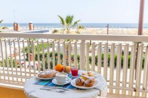 里米尼卡纳比酒店的海滩阳台的一张桌子上放着两盘食物