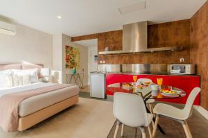 里斯本LX51 Studios & Suites by APT IIN的一间卧室配有一张床和一张桌子,上面有食物
