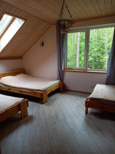 维尔纽斯Lesnoy holiday home的带两张床和两个窗户的房间