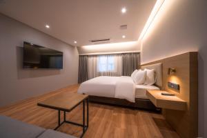 首尔Comfort inn Yeouido的卧室配有白色的床和电视。