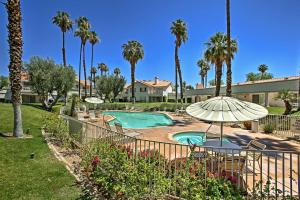 棕榈荒漠Newly Renovated Palm Desert Condo Community Pool!的一个带游泳池、遮阳伞和棕榈树的度假村
