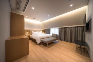 首尔Comfort inn Yeouido的配有一张床和一把椅子的酒店客房