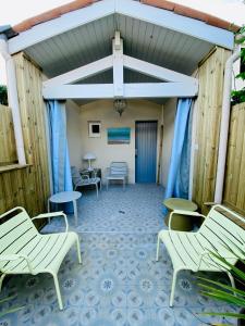 ChaucreCharming house close to the Plage des Huttes的庭院设有白色椅子和蓝色地板
