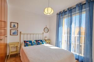 阿尔考斯布里Bellamar 3的一间卧室配有床和蓝色窗帘的窗户