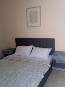 GoníaiPopi's Apartment的卧室内的一张床位,配有两张桌子和一张墙上的照片