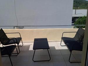 GoníaiPopi's Apartment的阳台配有3把椅子和1张桌子