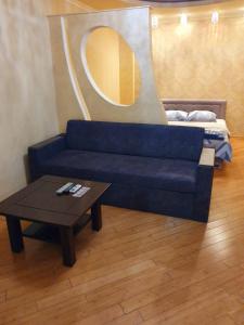 乌日霍罗德1-комнатная квартира ВИП уровня посуточно в Ужгороде. ул.И.Франка.的客厅配有蓝色的沙发和桌子