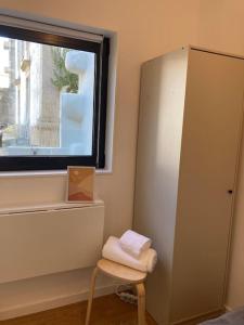 波尔图Oporto city center charming house的浴室设有毛巾,位于窗边的凳子上