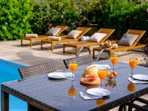 SimouAlmond Grove Luxury Villa Wprivate Pool的一张桌子,上面放着一盘食物和一杯橙汁