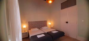 法鲁Hostel A Casa da Árvore的一间小卧室,配有两张床和两盏灯