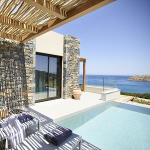 伊罗达Cayo Exclusive Resort & Spa的一座带游泳池和大海的别墅