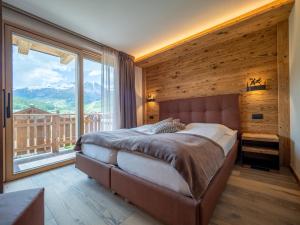 利维尼奥Deschana Lodge的一间卧室设有一张床和一个大窗户