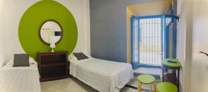 圣玛丽亚港Hostal Baobab的一间小卧室,配有两张床和镜子