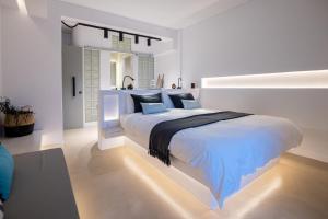 提诺斯SEAMENTO suites的白色卧室配有白色大床和蓝色枕头