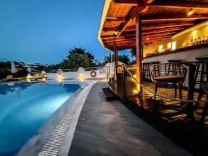 梅加利阿莫斯Spitaki Guest House的一座晚上的游泳池,有房子和建筑