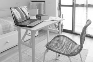 佩罗Casetta Azzurra的一张桌子,一张笔记本电脑和一把椅子放在房间里