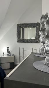 LeonforteCasa vacanze Europa的墙上设有一张桌子和镜子的房间