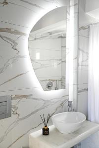 卡马利Villa Maina的浴室设有白色水槽和镜子