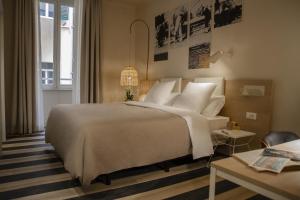 罗马room Select Via Veneto的卧室配有带白色枕头的大床