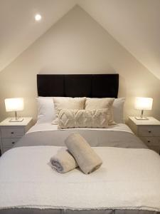 杜林The Cottage - Fairwinds的一间卧室配有一张带两盏灯的大型白色床。