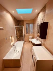 SiġġiewiLovely 3 bedroom in Siggiewi的带浴缸、卫生间和盥洗盆的浴室