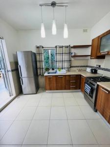 SiġġiewiLovely 3 bedroom in Siggiewi的厨房配有不锈钢冰箱和木制橱柜