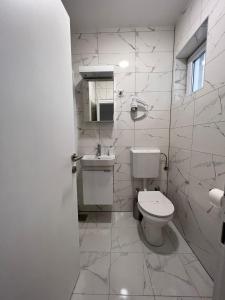 普纳特Villa Rosa Rooms的白色的浴室设有卫生间和水槽。