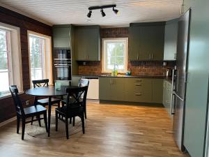 韦姆达伦Vemdalsskalet huset Myltan的厨房配有桌椅和冰箱。