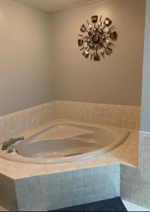 奥本代尔Florida Oasis的浴室里设有一个大浴缸,墙上有时钟