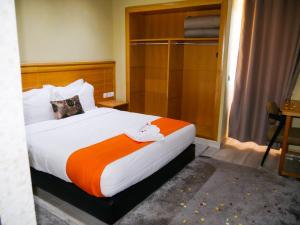 贝尼迈拉勒Hotel Golden Flora的一间卧室配有一张带橙色毯子的大床