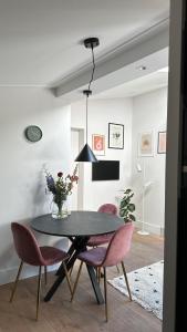 Rouveenbedandbreakfastrouveen的一间用餐室,配有黑桌和粉红色的椅子