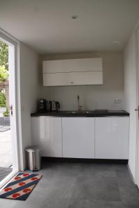 多克姆luxe ruime studio op unieke, rustige locatie的厨房配有白色橱柜和水槽