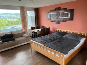 维尔茨堡schönes Apartment mit Festungsblick - FREE Parking -的一间卧室配有一张床、一张沙发和一张桌子
