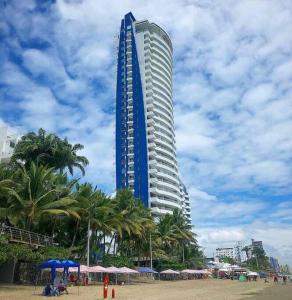 通苏帕Grand Diamond Beach, Dep 2 dormitorios的棕榈树海滩上一座高大的蓝色建筑