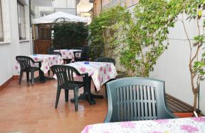 维亚雷焦德尔纳酒店的户外庭院配有桌椅和树木。